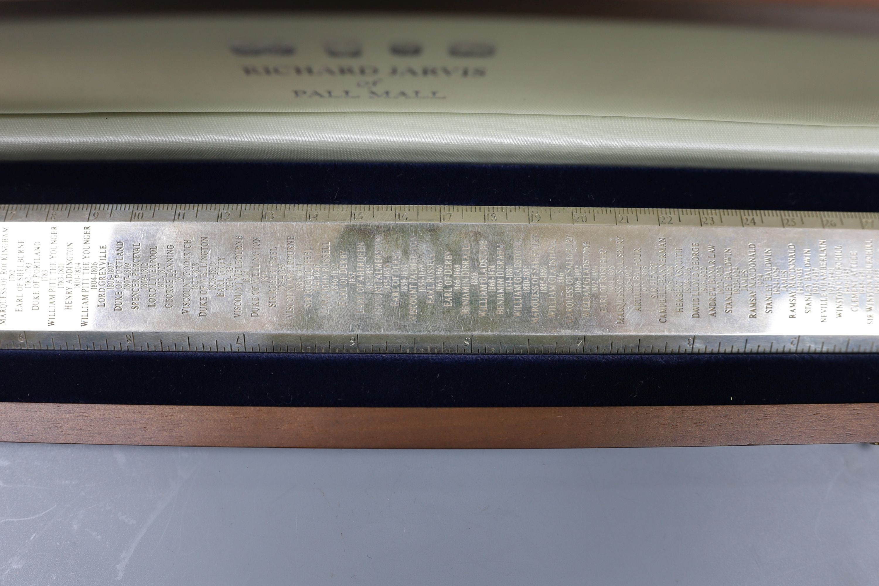 A cased modern silver 'Premier Rule' ruler, engraved with the names and dates of British Prime ministers, by Richard Jarvis, London, 2003, 10oz.